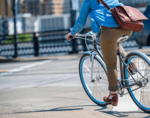 Woman With A Bag Rides A Bike
